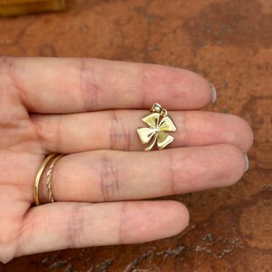 May include: A gold four-leaf clover charm pendant.