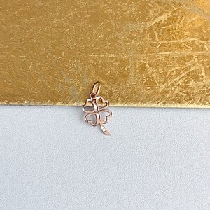 May include: A rose gold four-leaf clover charm pendant. The clover is detailed with a delicate pattern.