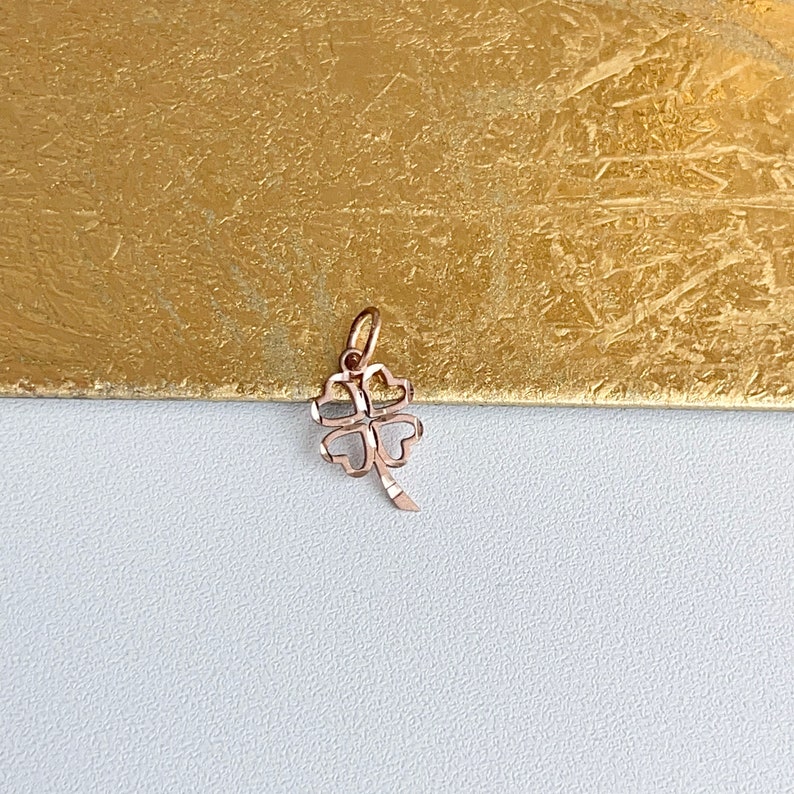 May include: A rose gold four-leaf clover charm pendant. The clover is detailed with a delicate pattern.