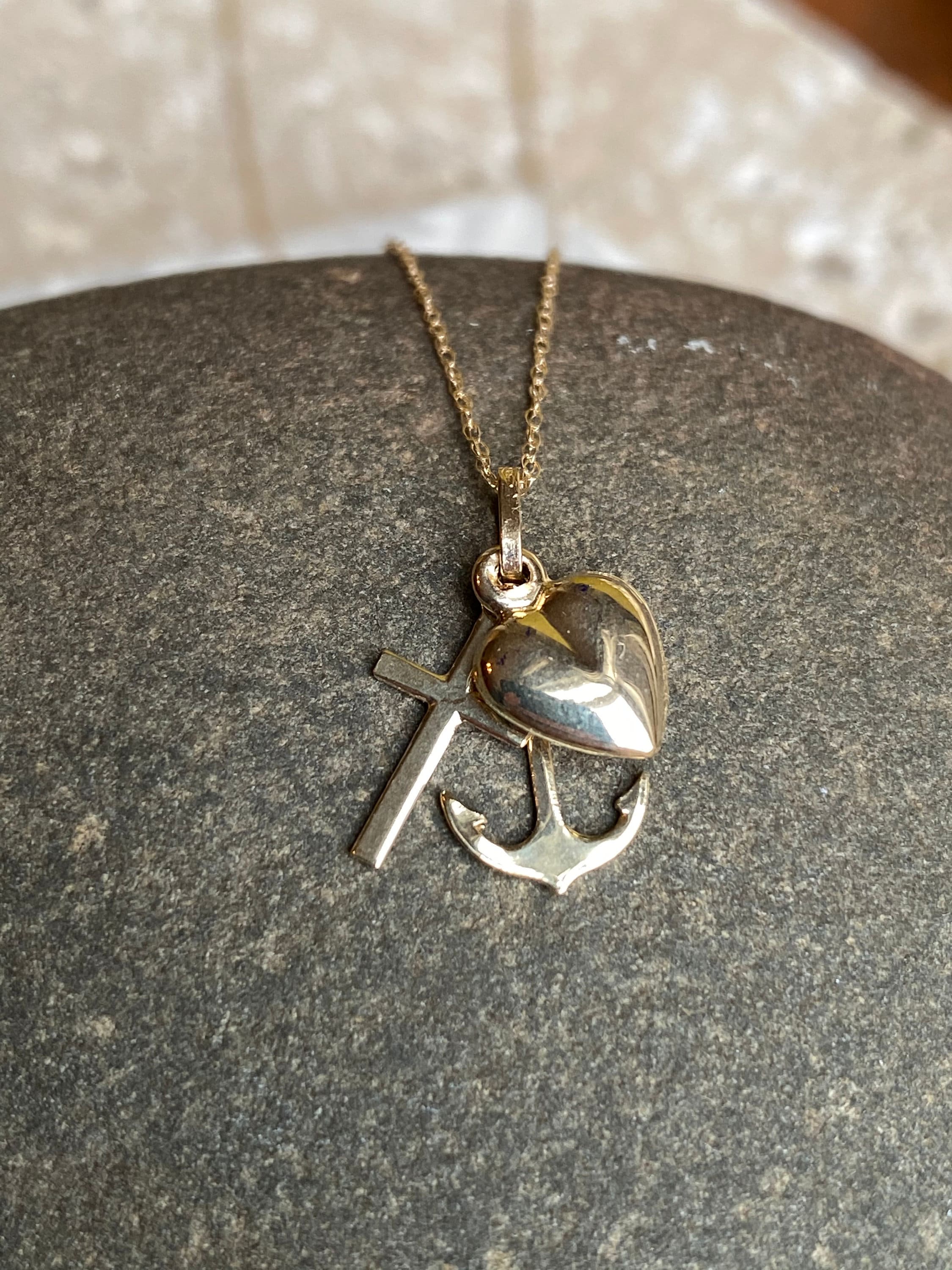 Catenina in metallo colore giallo a maglia con ciondolo bianco a forma di croce con pietre