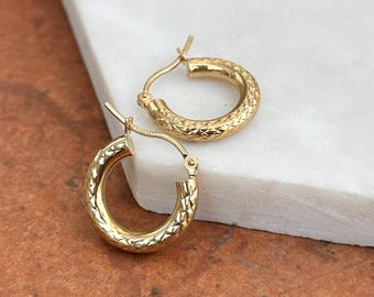 May include: A pair of gold hoop earrings with a textured diamond pattern.