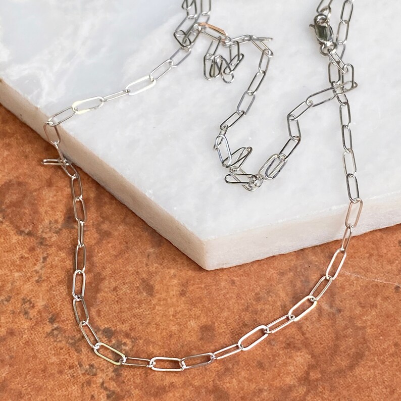 Pu&ograve; includere: Una collana a catena d'argento con un design delicato e collegato. La catena &egrave; composta da piccoli anelli ovali.