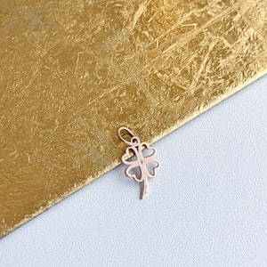 May include: A gold four-leaf clover charm pendant. The charm is made of gold and has a delicate design.