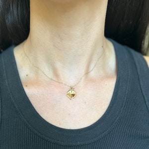 May include: A gold chain necklace with a four-leaf clover pendant.