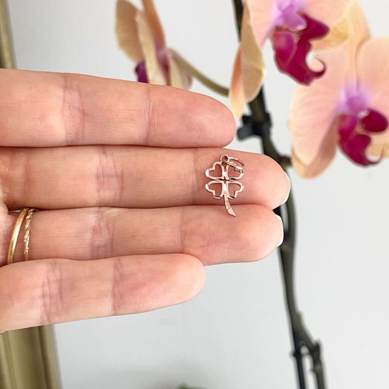 May include: A rose gold four-leaf clover charm pendant. The charm is delicate and features a detailed design.