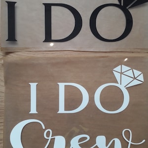 Peut inclure: Deux images de la phrase "I DO" avec un graphique de bague de diamant. L'image du haut est du texte noir sur un fond blanc. L'image du bas est du texte blanc sur un fond brun avec les mots "I DO Crew" en écriture cursive.