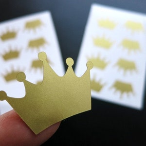 Op de afbeelding: Gouden kroon stickers op een wit vel papier. De kroon stickers zijn ongeveer 2,5 cm hoog.