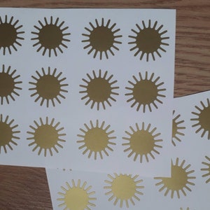 May include: A sheet of white paper with gold star stickers. The stickers are arranged in a grid pattern.