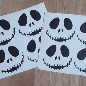 Puede incluir: Seis pegatinas de la cara de Jack Skellington en blanco y negro en dos hojas de papel blancas.