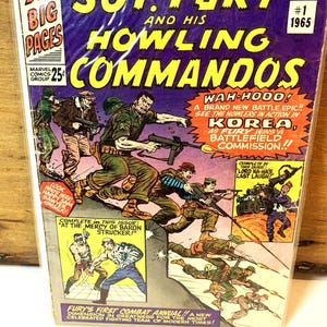 Peut inclure: Une bande dessinée vintage intitulée "Sgt. Fury and His Howling Commandos" #1, 1965. La couverture présente une illustration dynamique de soldats au combat, avec des lettres jaunes et bleues audacieuses. La bande dessinée est une publication de Marvel Comics Group.