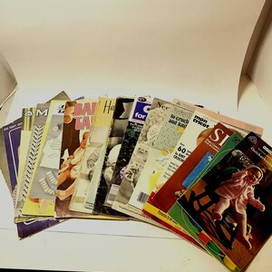 May include: A selection of vintage knitting and crochet pattern booklets. The covers display images of babies and various knitted and crocheted items. Titles include "Baby Talk," "Quickerknits," and "Needle-Baby." The booklets are fanned out.