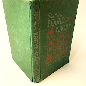 May include: A vintage green hardcover book titled "The New Round About" with brown lettering and illustrations. The spine shows the title vertically. The cover features a house, animals, and figures.