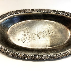 May include: An oval silver serving tray with an ornate border and the word "Bread" engraved in the centre.