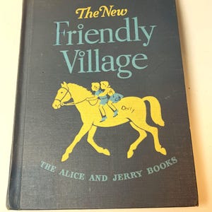 以下が含まれることがあります： 青い表紙の「The New Friendly Village」というタイトルのヴィンテージハードカバー本。表紙には、2人の子供が乗った馬の黄色のイラストが描かれています。「THE ALICE AND JERRY BOOKS」というテキストが下部に印刷されています。
