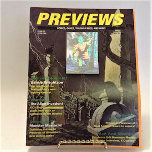 May include: A magazine cover for Previews, a publication for comics, games, trading cards, and more. The cover features a dark, spooky illustration of a graveyard with a black cat sitting on a tombstone. The magazine title is in yellow letters and the text "Horror Hologram! Bernie Wrightson" is visible in the top left corner.