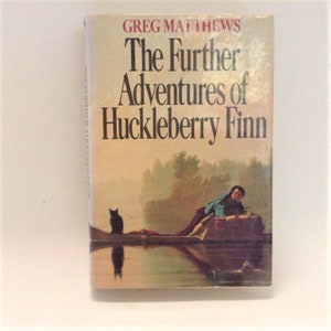 May include: A book cover featuring a painting of a person sitting on a rock by a river with a black cat sitting on a log. The title of the book is "The Further Adventures of Huckleberry Finn" by Greg Matthews.
