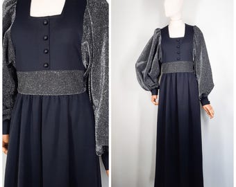 May include: A black maxi dress with long sleeves and a silver glitter overlay on the sleeves. The dress has a square neckline and a button closure at the front.