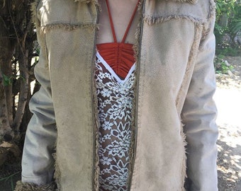 May include: A beige suede jacket with a faux fur collar and cuffs. The jacket has a zipper closure and a brown lining.