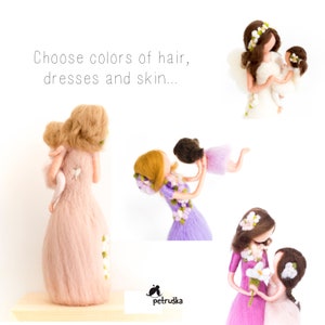 May include: Two felt dolls, one holding the other, with flowers in their hair and dresses. The dolls are made in a whimsical style and are perfect for a child's room.