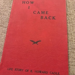 Könnte beinhalten: Ein rotes Buch mit dem Titel "HOW I CAME BACK" in schwarzer Schrift. Das Cover enthält auch den Text "LIFE STORY OF E. HOWARD CADLE" und ein kleines Emblem. Das Buch hat eine strukturierte Oberfläche und ist wahrscheinlich vintage.