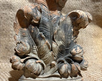 Fragmento arquitectónico antiguo de yeso de la época victoriana: sujetalibros ornamentado con hojas de acanto y motivos florales en espiral. Decoración shabby chic de estilo shabby chic.