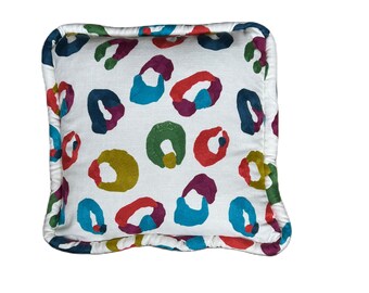 Weiße Leinenmischung mit bunten gestickten Formen.