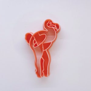 May include: A pink plastic cookie cutter shaped like a dodo bird.