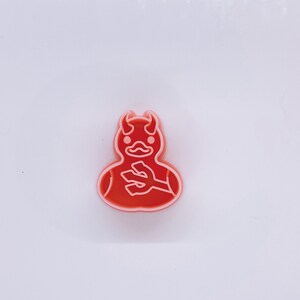 May include: Red plastic cookie cutter shaped like a devil duck with horns and a trident.