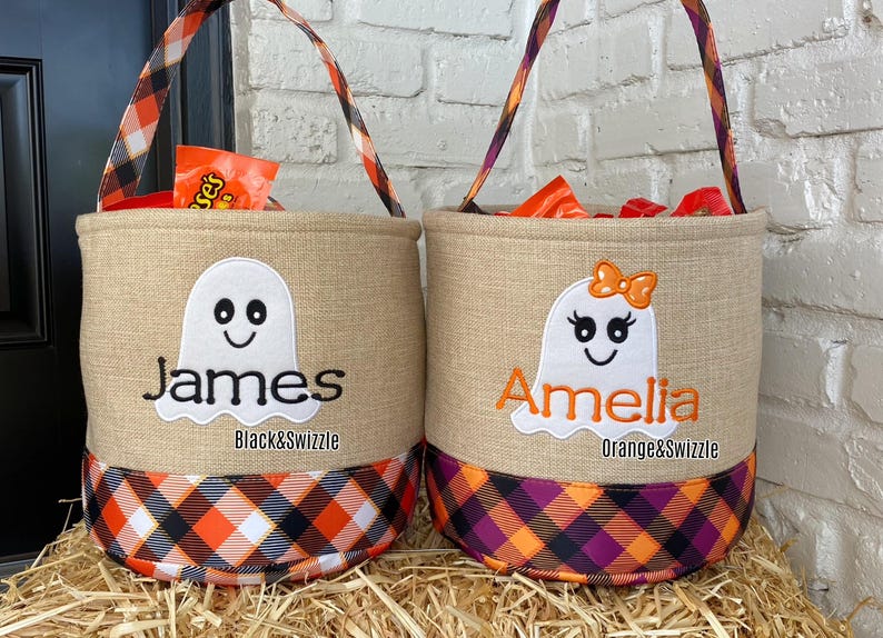 May include: Two burlap trick-or-treat bags with ghost designs. One bag is orange and black plaid with the name Amelia and the text "Orange&Swizzle". The other bag is black and white plaid with the name James and the text "Black&Swizzle".