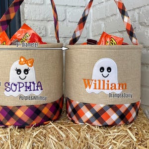 May include: Two personalized Halloween treat bags with ghost designs. The bags are 9 inches tall and 9 inches in diameter. One bag is decorated with purple and orange plaid and says "Sophia Purple&Whimsy". The other bag is decorated with orange and black plaid and says "William Orange&Daily".