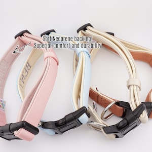 May include: Three dog collars in pink, light blue, and cream with black buckles. The collars have a soft neoprene backing for comfort and durability. The pink collar has the word "BELLA" embroidered on it.