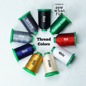 May include: A variety of thread spools in different colors, including black, dark gray, gray, navy, gold, cream, white, red, and Christmas green. The spools are arranged in a circle on a white background. The text "Thread Colors" is in the center of the circle.