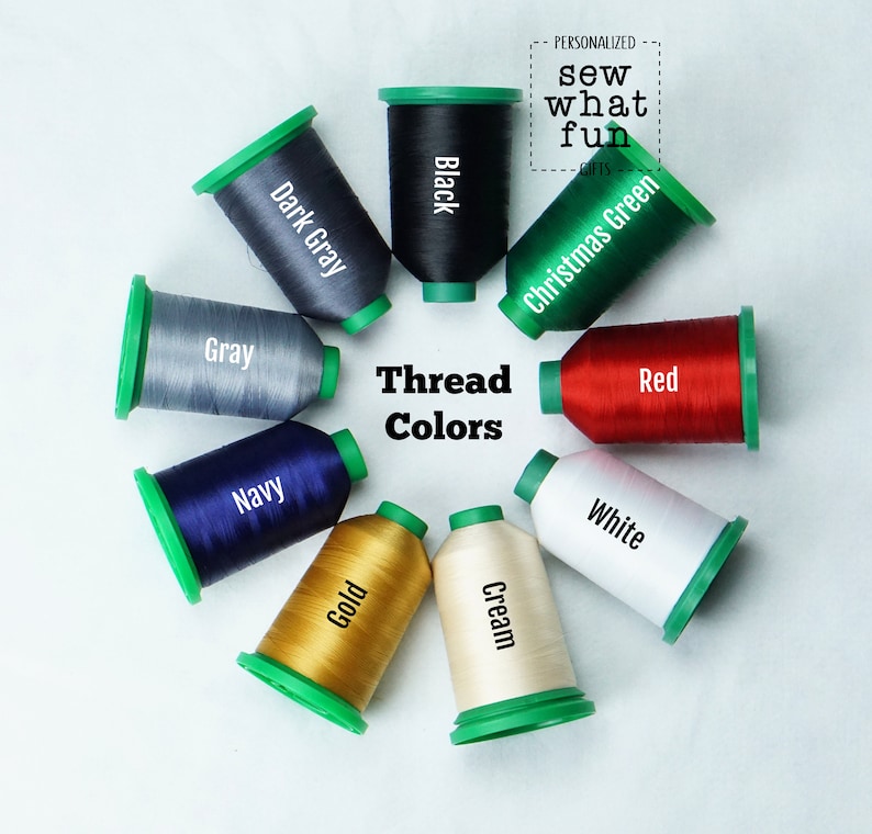 May include: A variety of thread spools in different colors, including black, dark gray, gray, navy, gold, cream, white, red, and Christmas green. The spools are arranged in a circle on a white background. The text "Thread Colors" is in the center of the circle.