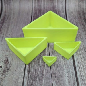 May include: Four lime green triangular shaped dishes of varying sizes. The dishes are made of a smooth, hard plastic.