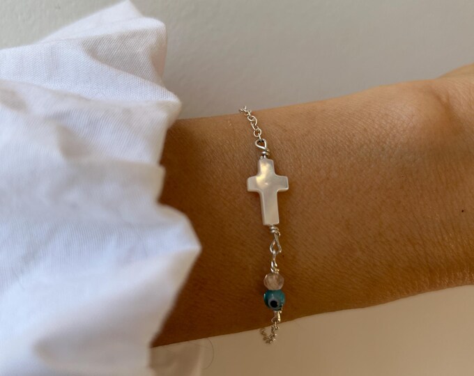 Mother of pearl sideways cross bracelet with evil eye and birthstone.