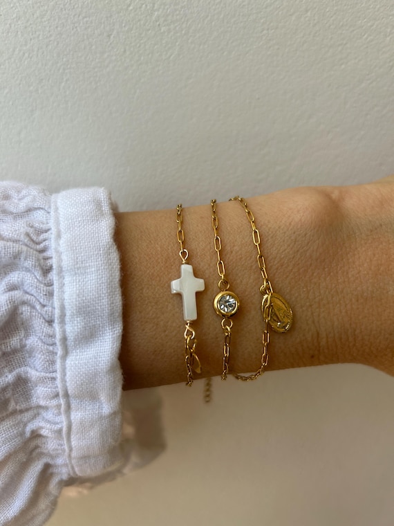 Bracelet stack. Side ways cross bracelet. Tiny Madonna charm. Rhinestone charm bracelet. Gold, silver stainless steel paper clip chain.