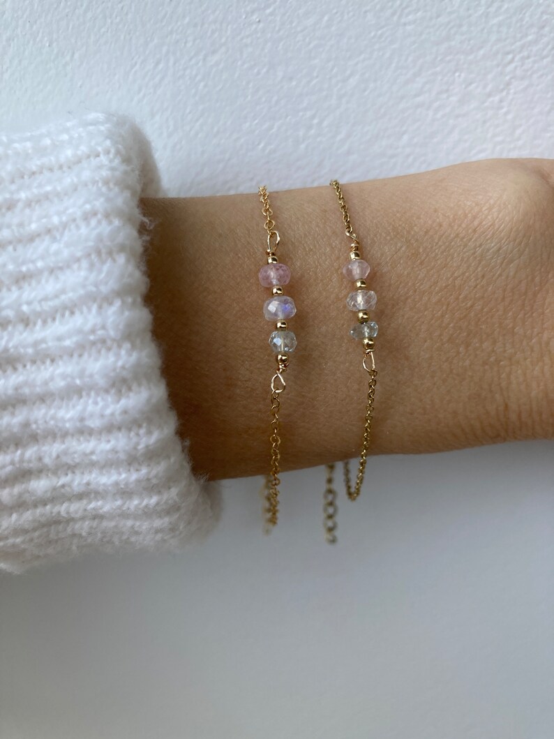 May include: Two delicate gold chain bracelets with small pink and clear gemstone beads.