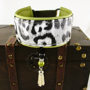 Könnte beinhalten: Ein schwarz-weiß gemustertes Hundehalsband mit grünem Lederbesatz und einem grünen und schwarzen Perlen-Quaste.