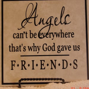 May include: A beige ceramic tile with black text that reads "Angels can't be everywhere that's why God gave us FRIENDS".