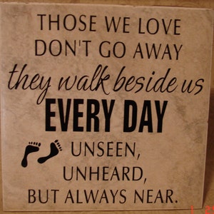 May include: A beige tile with black text that reads "Those we love don't go away, they walk beside us every day, unseen, unheard, but always near."