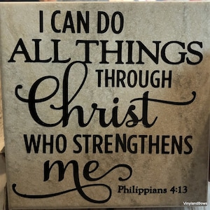 May include: A beige tile with black lettering that reads "I can do all things through Christ who strengthens me Philippians 4:13".