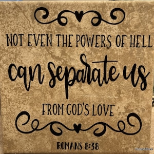 May include: A brown tile with a black inscription that reads "NOT EVEN THE POWERS OF HELL can separate us FROM GOD'S LOVE ROMANS 8:38". The inscription is surrounded by decorative swirls and hearts.