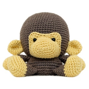 May include: A crocheted monkey toy with brown fur and yellow ears, nose, and hands.