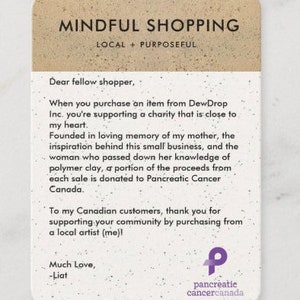 May include: A handwritten note on a beige background with brown speckles. The note reads "Mindful Shopping, Local + Purposeful". The note also includes a message about supporting a charity that is close to the writer's heart. The note is signed "Much Love, -Liat" and includes a purple ribbon logo for Pancreatic Cancer Canada.