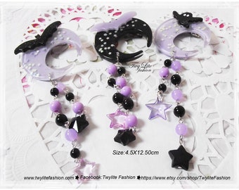 May include: Three purple and black crescent moon hair clips with dangling chains of purple and black beads and star charms. The clips are 4.5 inches by 12.5 inches.