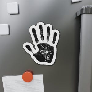 Puede incluir: Un imán de huella de mano en blanco y negro con el texto "NOT PENNY'S BOAT" en un refrigerador plateado.