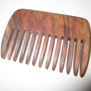May include: A brown wooden comb with a curved handle and fine teeth.