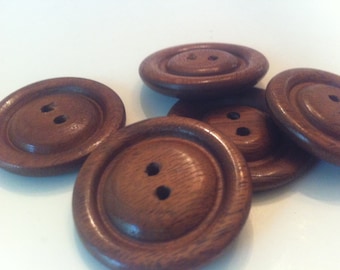 May include: Five wooden buttons with two holes each. The buttons are brown and have a smooth, polished finish.