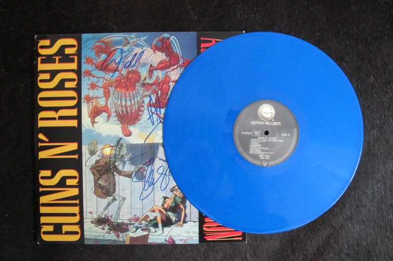 May include: A blue vinyl record with the text "Guns N' Roses" and "Appetite for Destruction" on the cover. The record is signed by the band members.