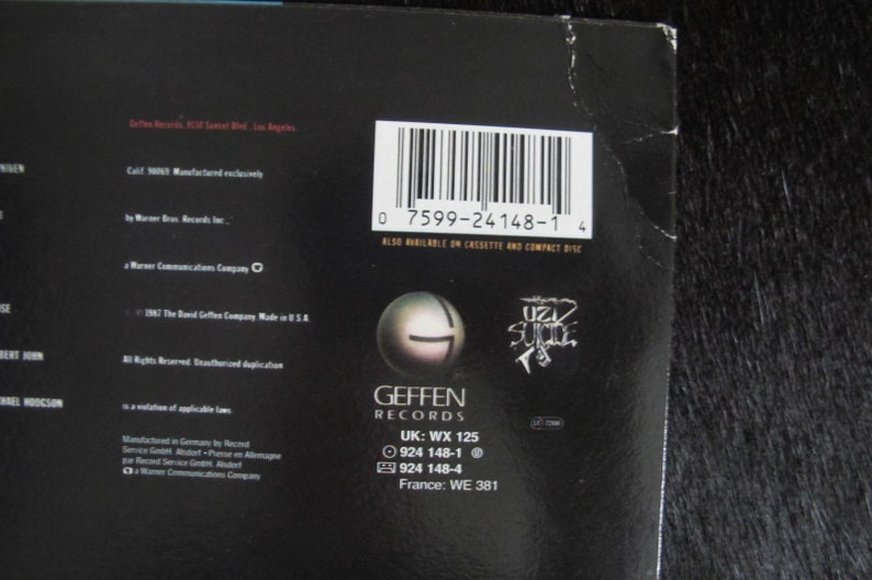 May include: Black and white record album cover with the band name "Uzi Suicide" in a stylised font. The album is by Geffen Records and has the barcode 0 7599-24148-1 4. The album is also available on cassette and compact disc.